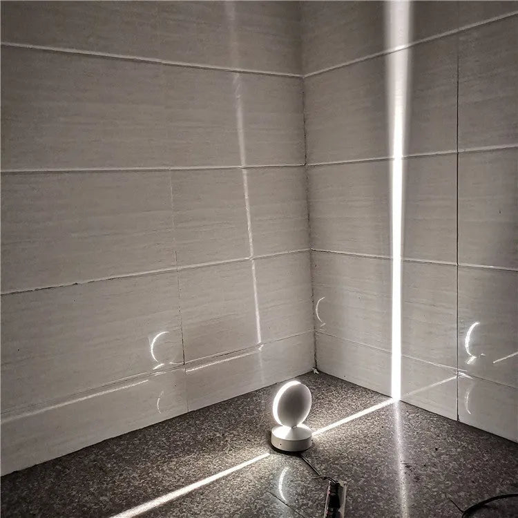 Modern aluminium spotlight bar wall lamp with glass lens, mounted on a wall.
