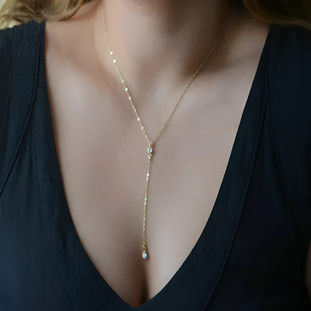 Gold alloy snake bone chain necklace with geometric pendant on display
