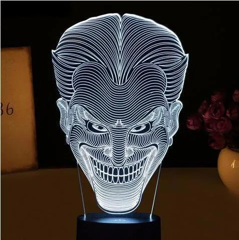 USB-powered 3D acrylic LED lamp displaying multiple colours on a desk with remote control.
