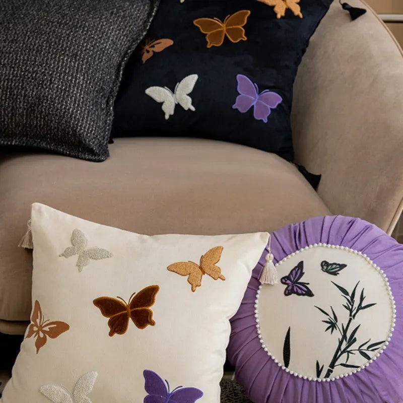 Square beige cushion with colourful embroidered butterfly and Chinese floral pattern.