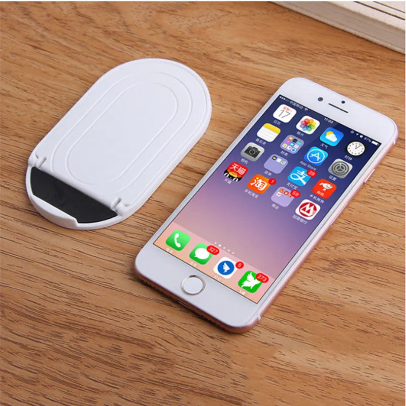 Plastic lazy bracket phone stand holding a mobile phone, shown in multiple colour options