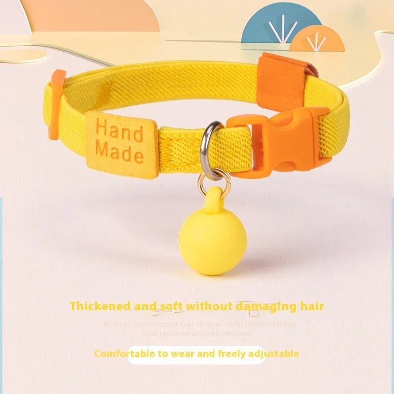 A stretchy yellow polyester dog collar for small breeds, shown adjusted to fit, with a metal D-ring.