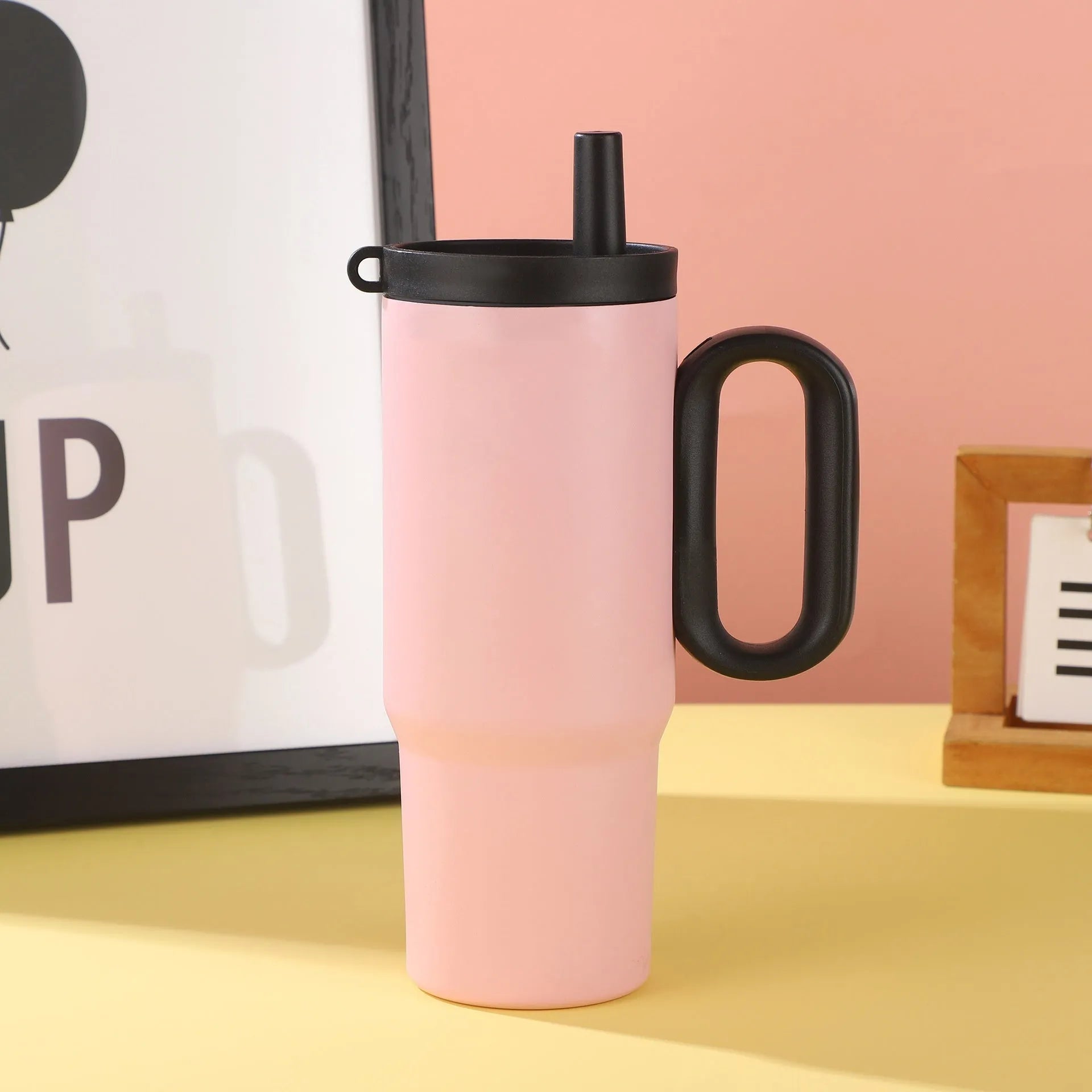A large insulated portable cup with a handle, shown in multiple colour options.