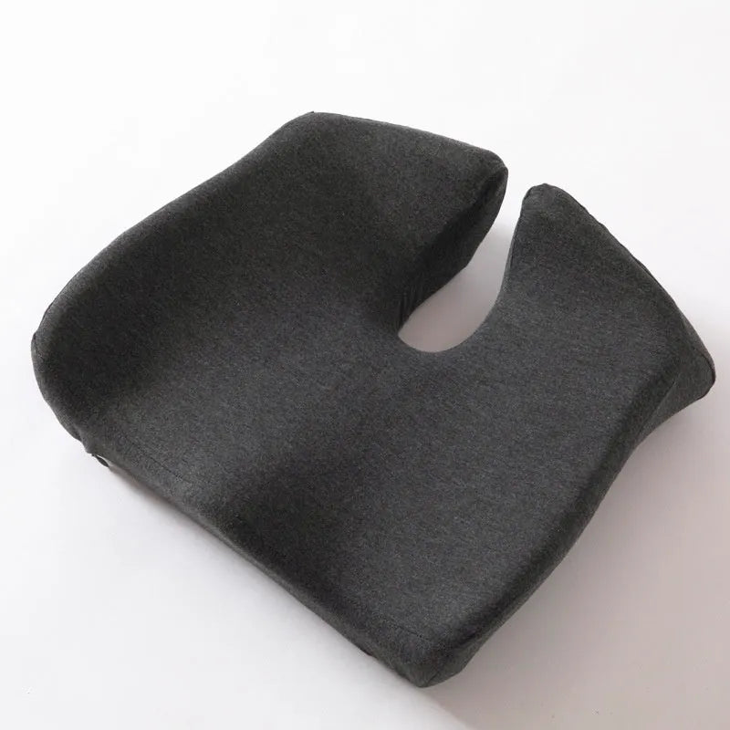 Dark grey memory foam office chair cushion for lumbar support on a desk chair.