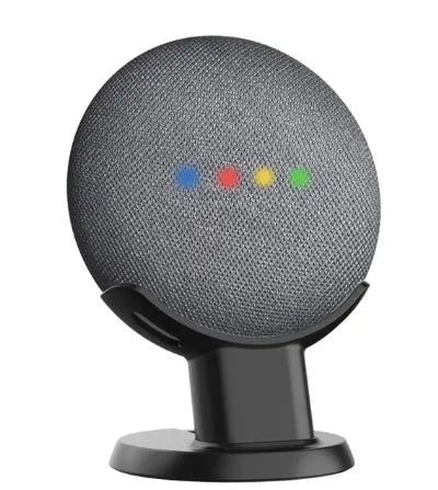 Black plastic stand holding Google Home Mini speaker on wooden desk