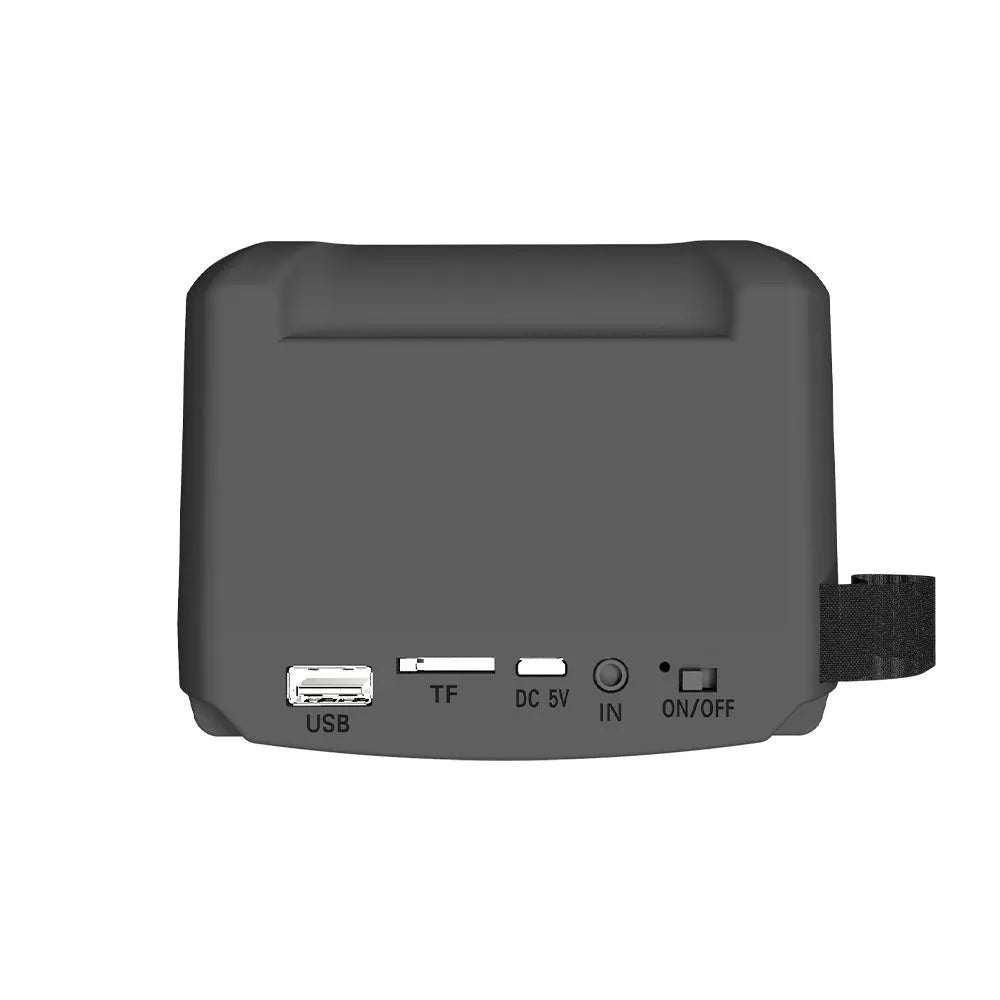 Compact rectangular portable Bluetooth speaker with USB charging cable on a desk.