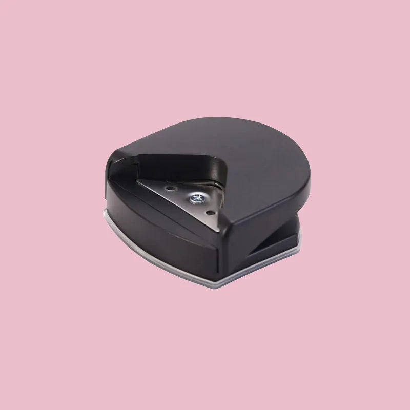 Black, blue, and pink plastic and metal business card corner cutter tool on a white background.