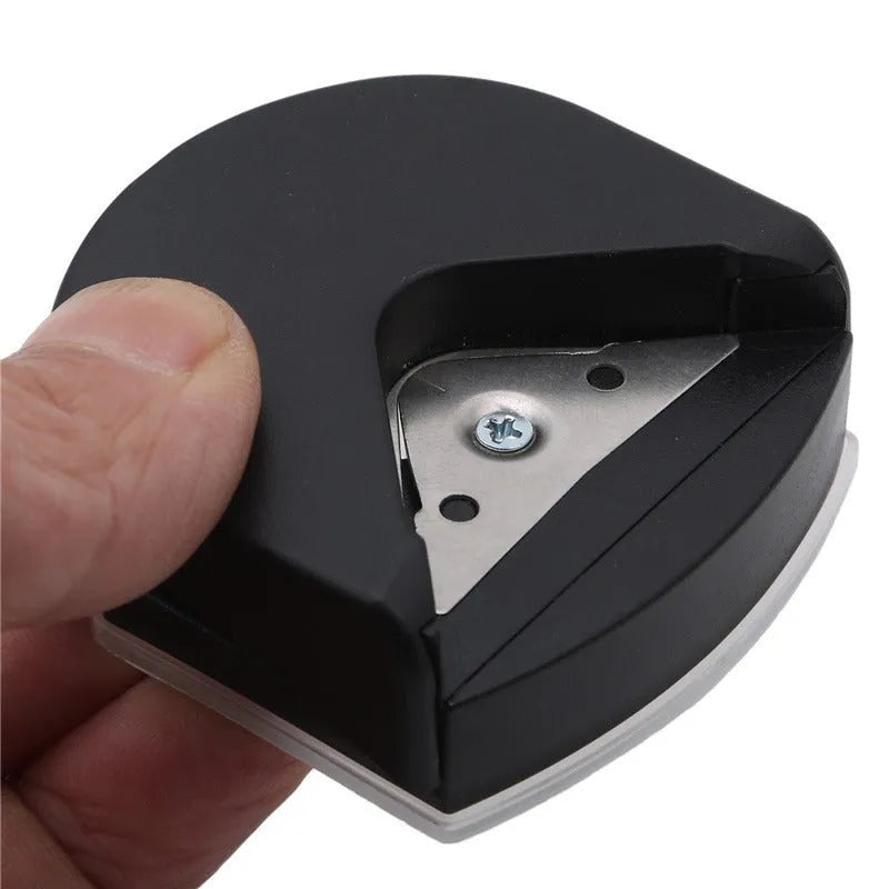 Black, blue, and pink plastic and metal business card corner cutter tool on a white background.