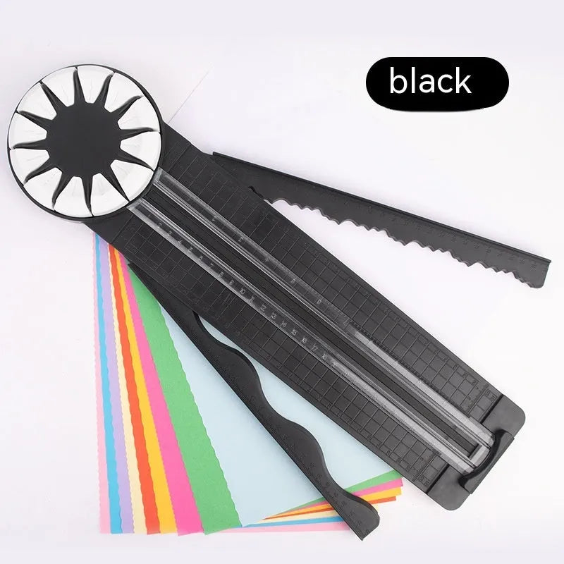 Pink and black 12-in-1 dotted line plastic rotary paper cutting machine on a craft table.