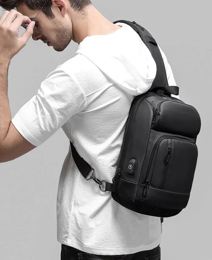Black medium-sized PVC shoulder bag showing front zipper, air cushion strap, and internal laptop pocket.