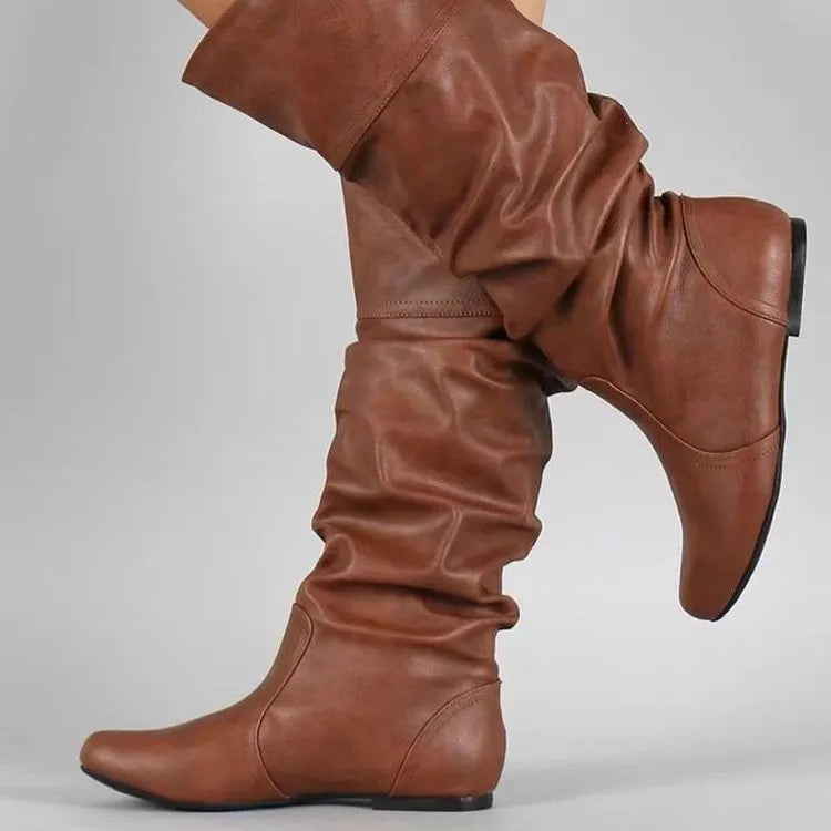 Women's black slip-on knee-high flat boots with a round toe and rubber sole.