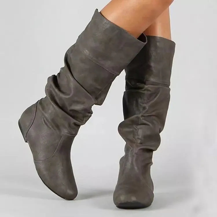 Women's black slip-on knee-high flat boots with a round toe and rubber sole.