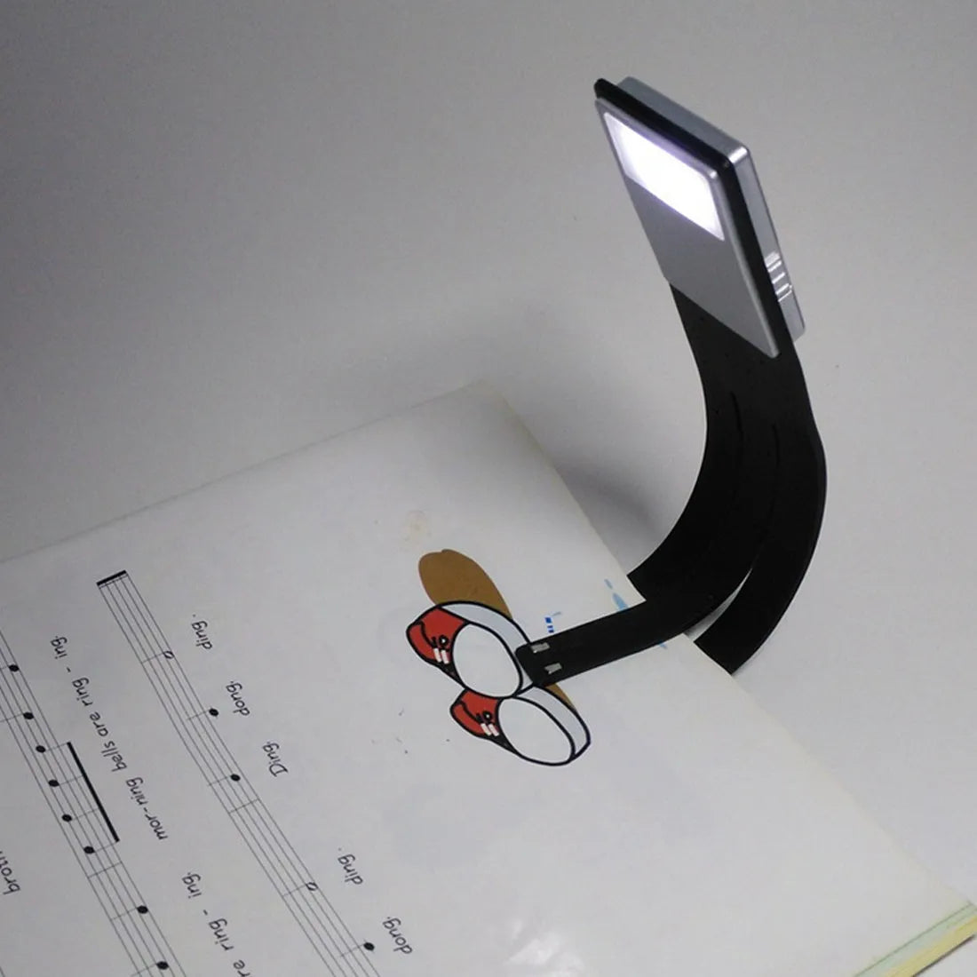 LEDGLE black USB rechargeable flexible clip LED book light with frosted panel and silicone arm on an e-reader