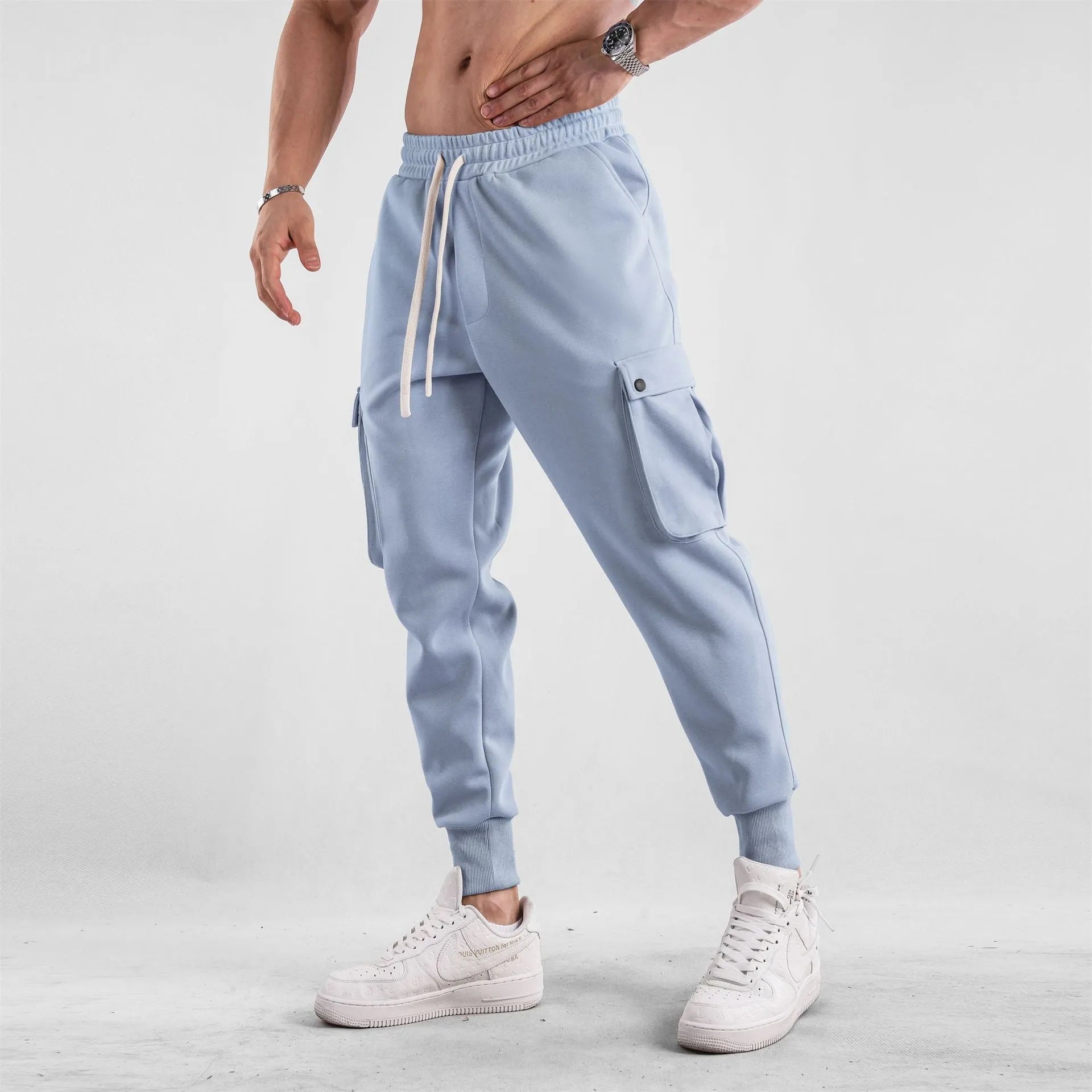 Men's loose-fit apricot coloured cotton sports trousers with an ankle tie and side pockets on a neutral background.