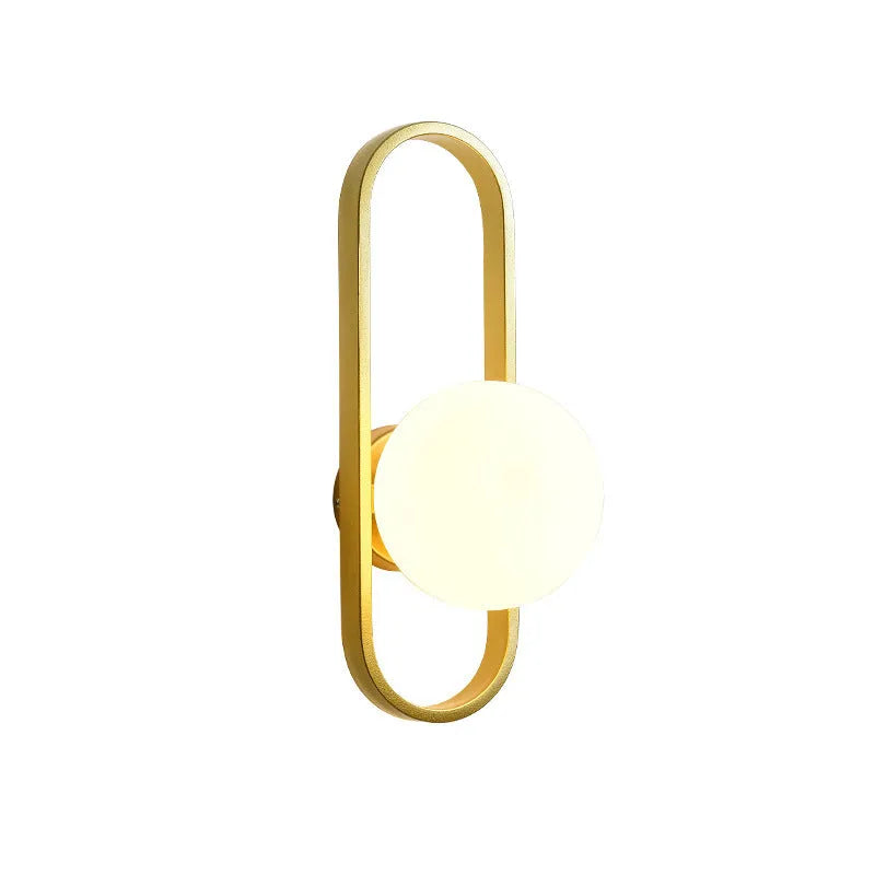 Minimalist black iron wall sconce lamp with glass shade mounted beside a bed.