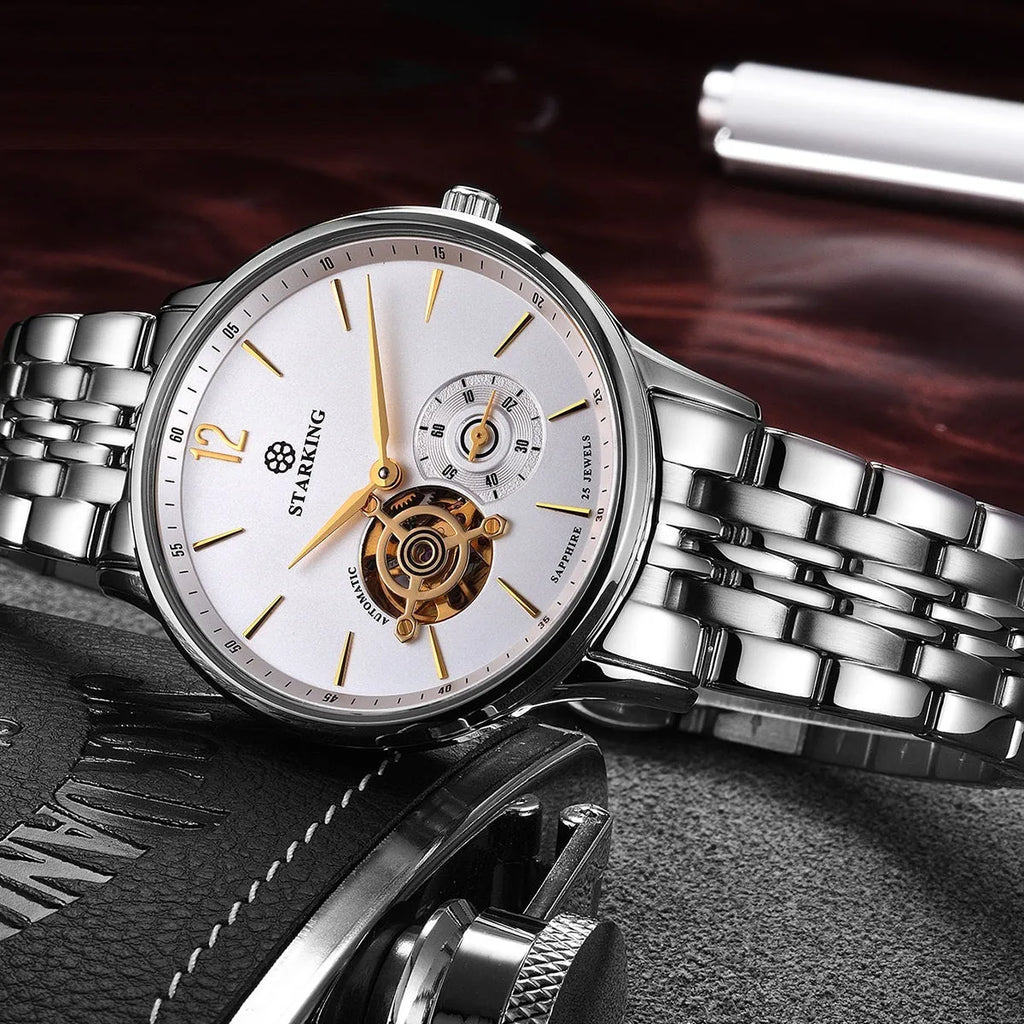 Men's stainless steel automatic watch with brown leather strap and hollow three-needle dial on white background.