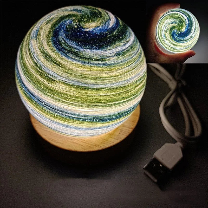 Modern planet-shaped USB night light with dimming on a desk.