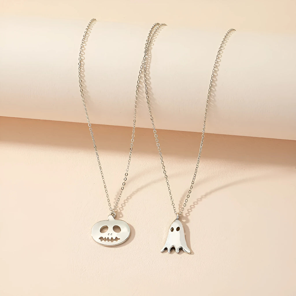 Two silver alloy pendant necklaces: one cartoon pumpkin and one cartoon ghost on a light background