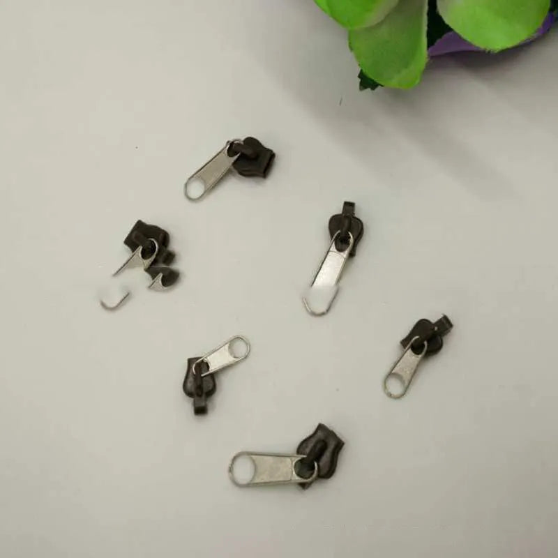 Snap-on zipper head repair kit with 12 plastic and metal pull tabs in black, grey, and coffee colours.