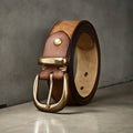 Men's brown casual leather belt with a copper pin buckle shown on a pair of jeans