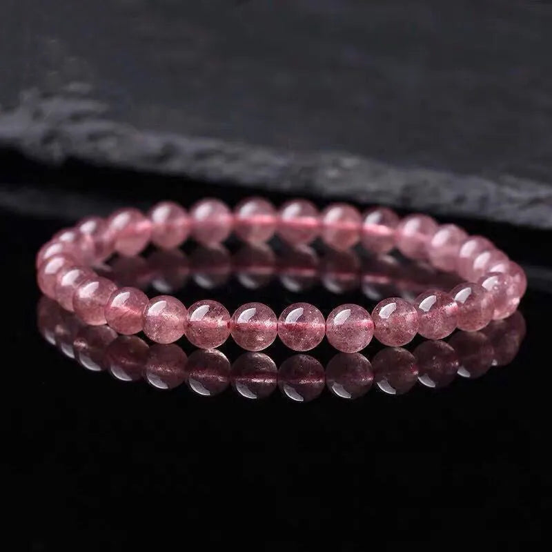 Women's adjustable bracelet with round, polished strawberry quartz crystal beads.