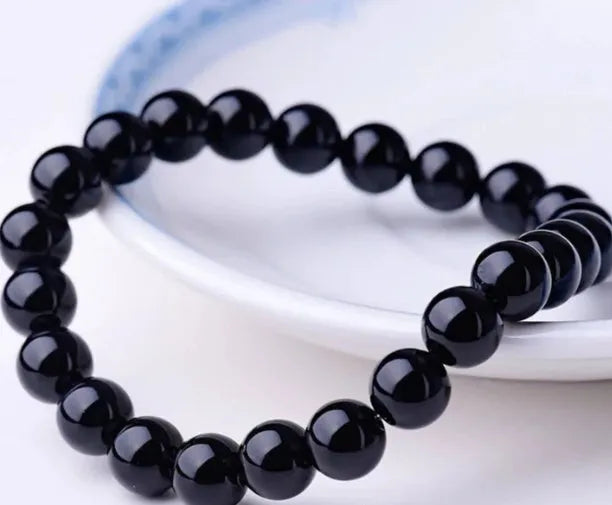 Geometric black onyx stretch bracelet with 8mm agate beads on an elastic cord.