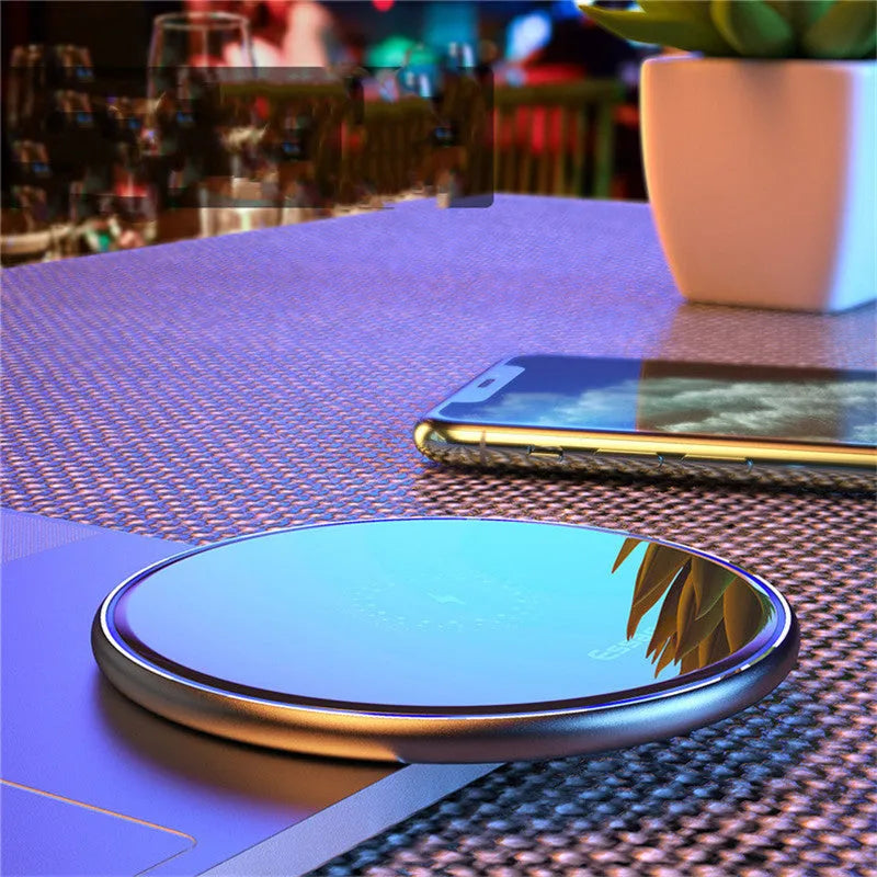 Black aluminium alloy 15W Qi fast wireless charging pad on a wooden desk