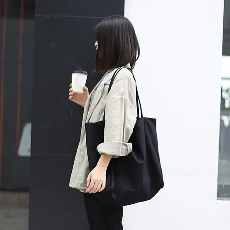 Large canvas shoulder tote bag in solid colour with soft handle, open top, and internal phone pocket