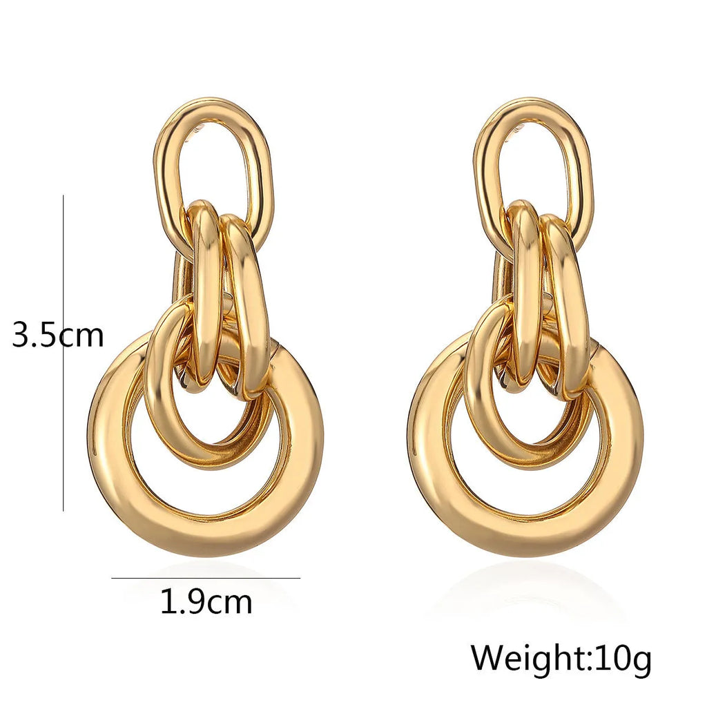 Gold geometric drop earrings with irregular design elements on copper base