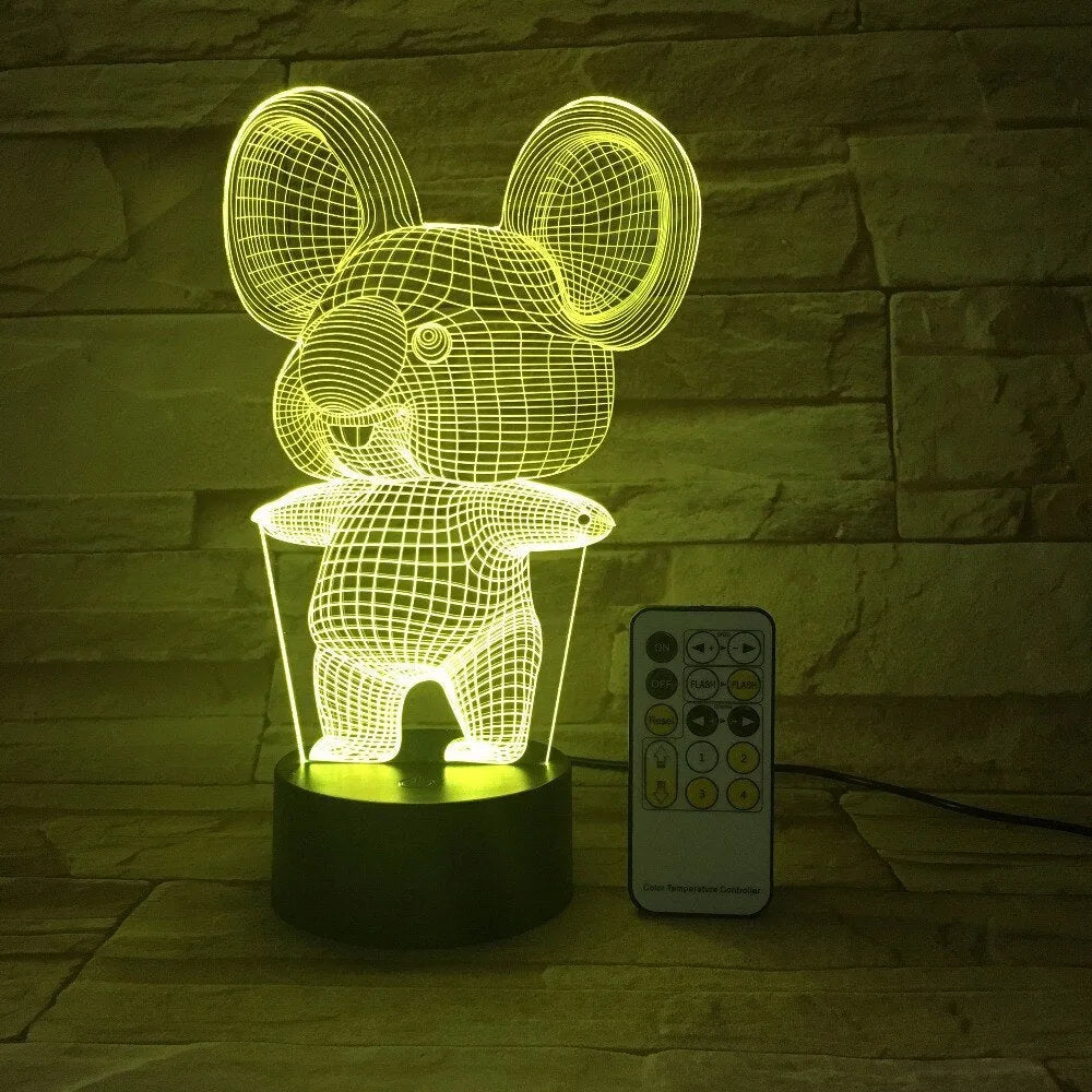 Black koala-shaped LED night light with remote control on a table.