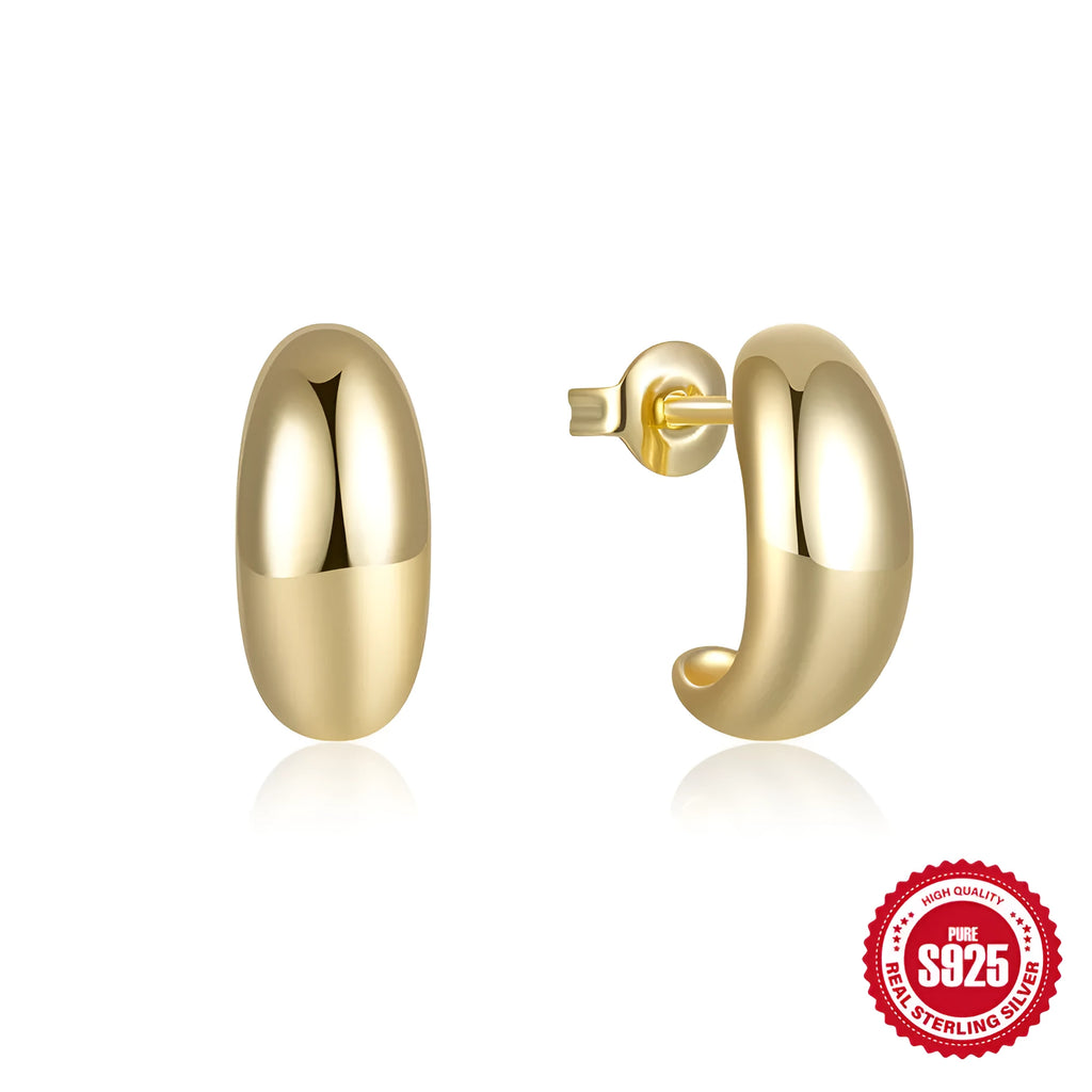 Close-up of a glossy C-shaped sterling silver stud earring on a gold background.