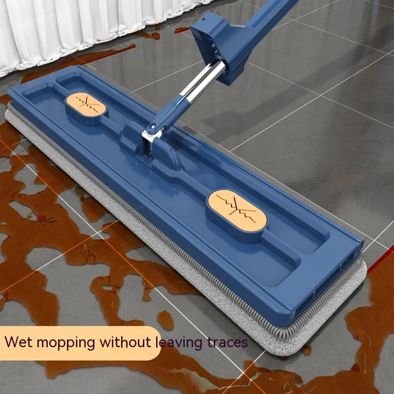 Large blue flat mop with a long stainless steel handle and a rotating head on a wooden floor.
