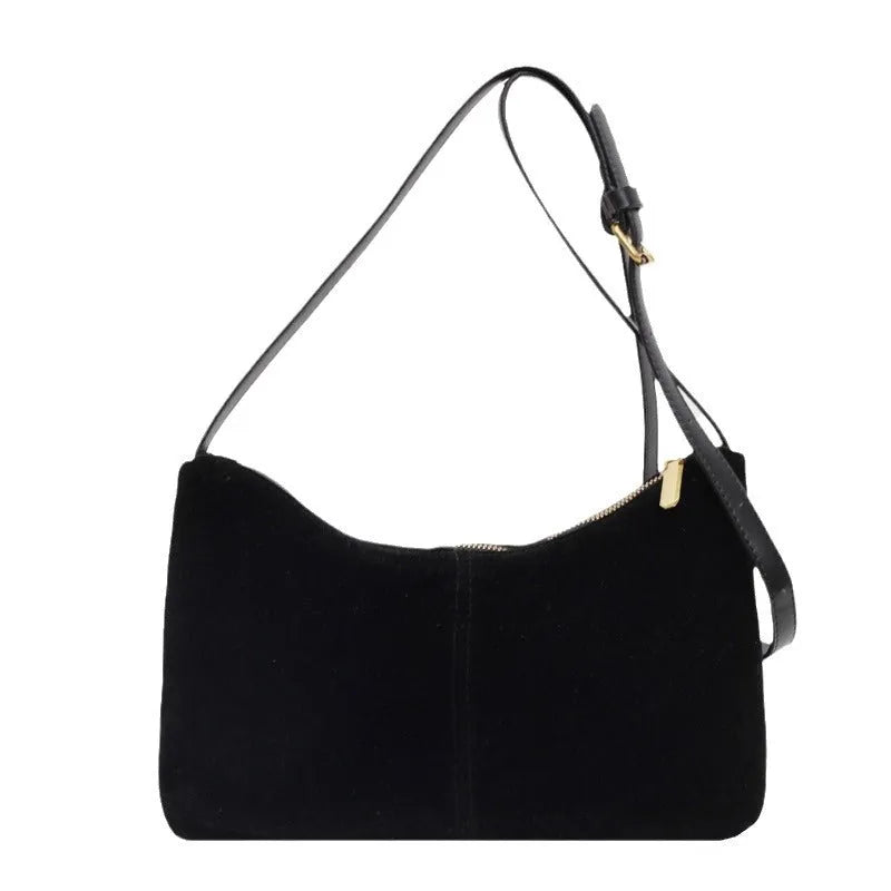 Retro brown suede underarm bucket bag with visible sewing line detail on a woman's shoulder during commute