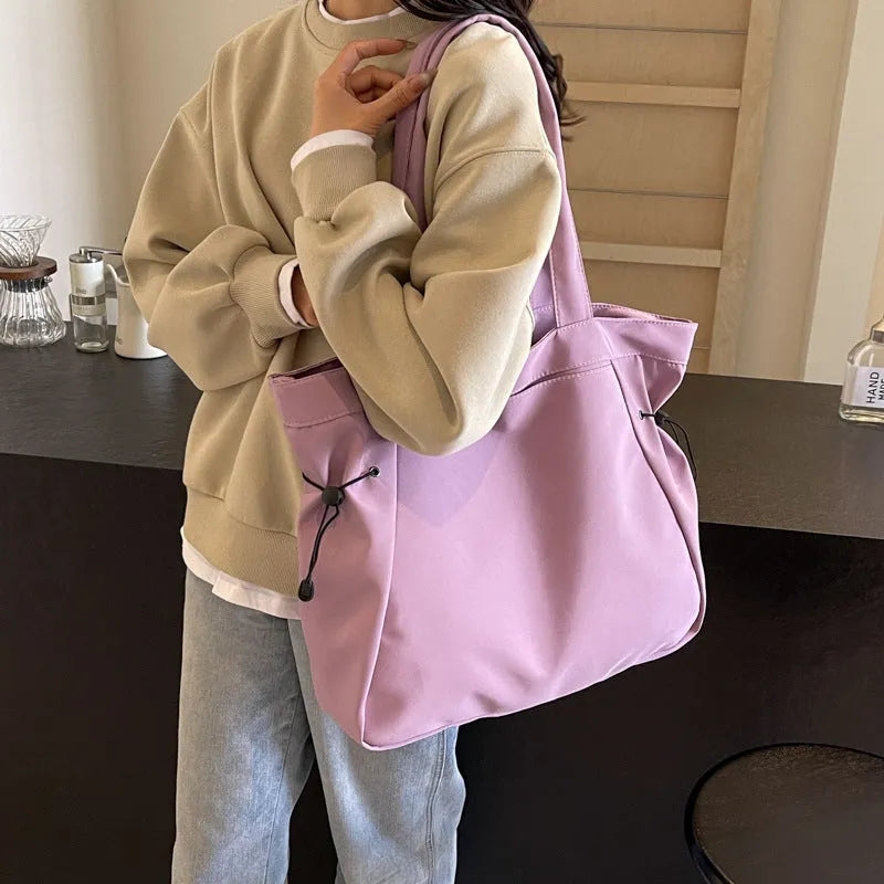 Soft foldable Oxford cloth shoulder tote bag in a street style, shown in various colours.
