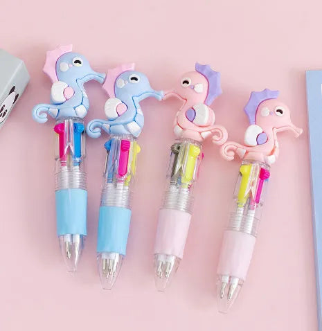 A press-action ballpoint pen with a four-colour cartridge, showing one of five random cartoon designs on the barrel.
