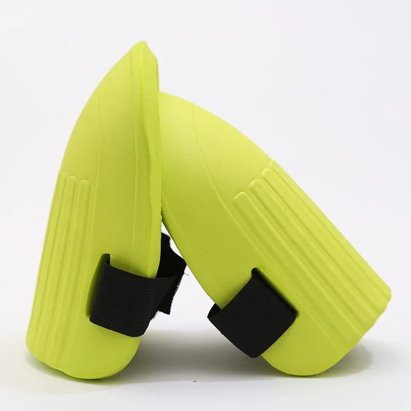 A pair of rectangular EVA foam knee pads in army green colour on a garden soil background.