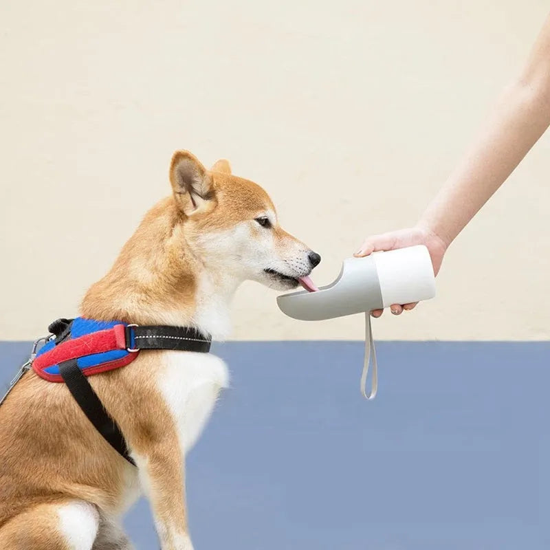 White and grey Moestar Rocket shaped pet water bottle with cup head and lock button.
