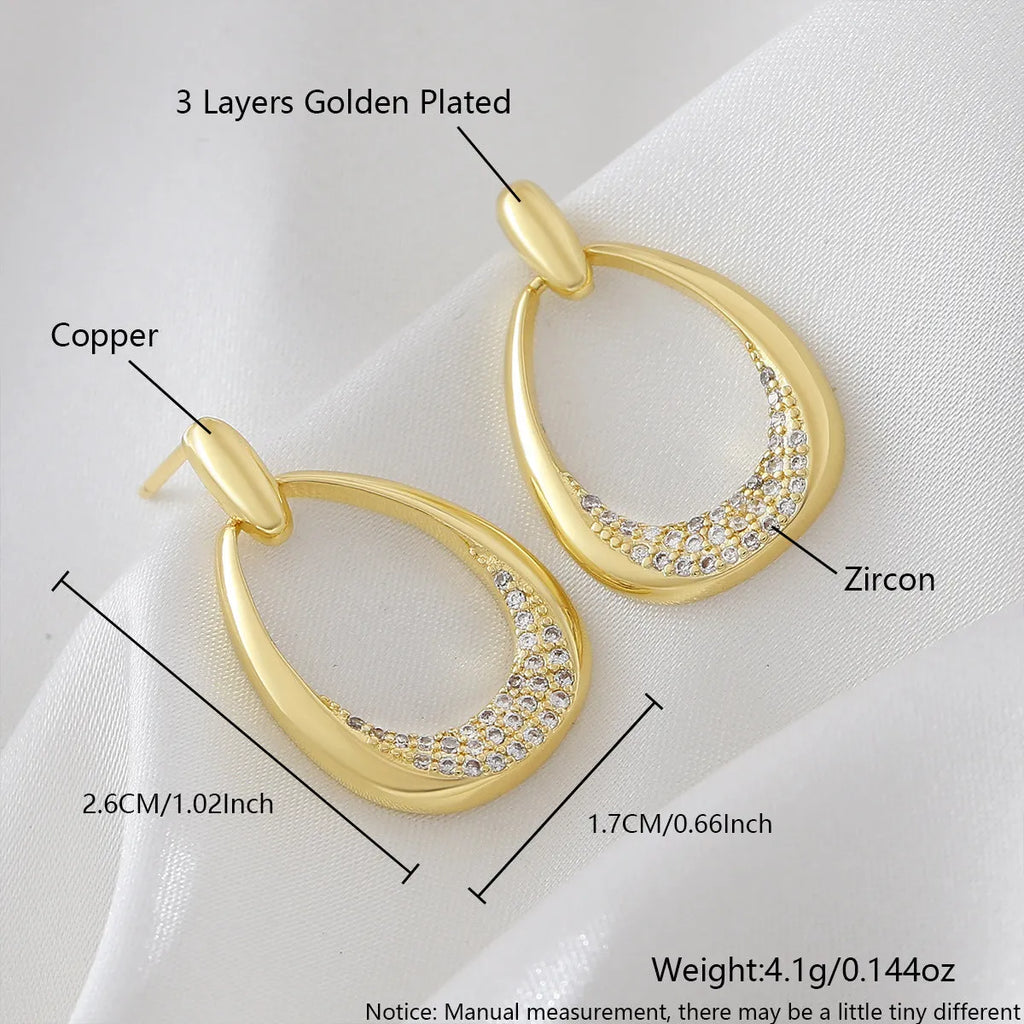 Yellow gold geometric drop earrings for women on a plain background, showing their 2.6 cm length.