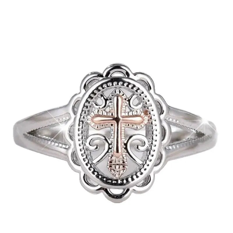 Silver women's ring with detailed cross and lace pattern, shown on a finger.