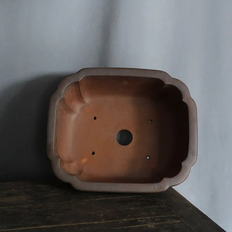 A rectangular purple sand clay bonsai pot on a floor, showing its modern simple design.