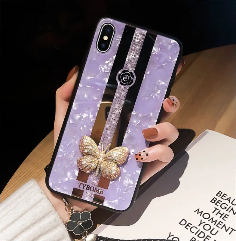 Luxury acrylic iPhone case with crystal butterfly design and mirror back, shown in purple.
