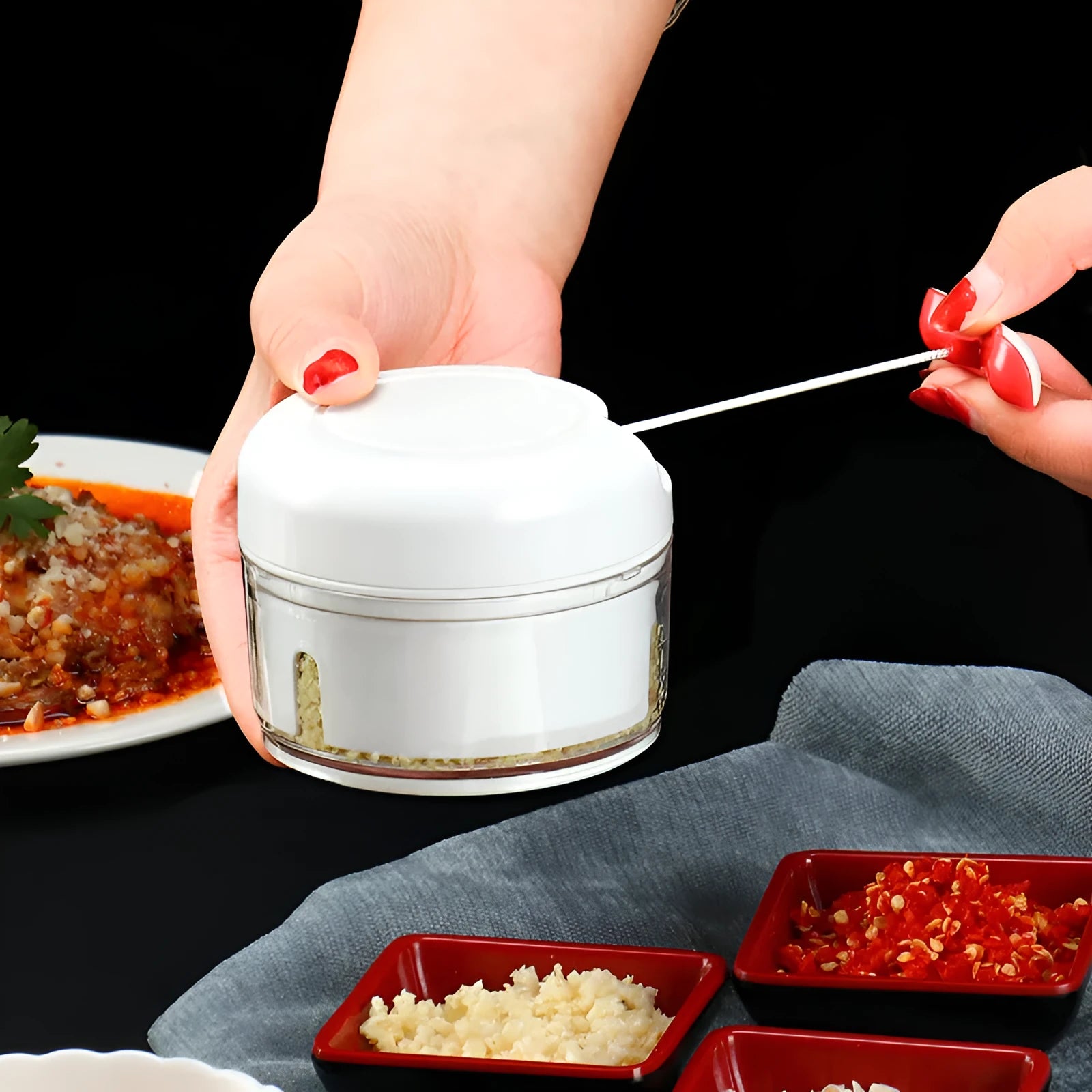 Compact manual food chopper with stainless steel blades for chopping vegetables, garlic, and ginger.