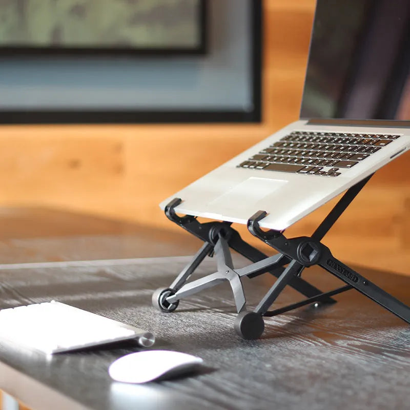 Black folding portable laptop stand made of reinforced nylon, shown open and folded to 4cm depth.