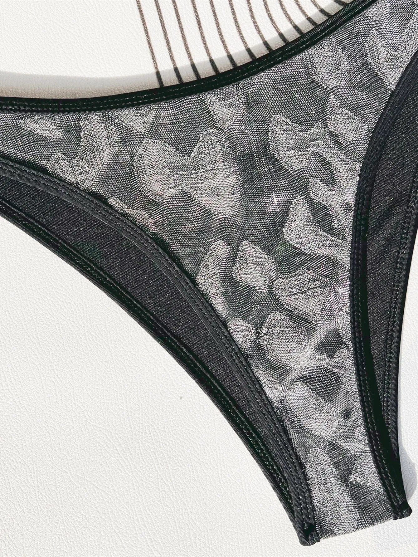 Women's black bikini set with strap design for swimming.