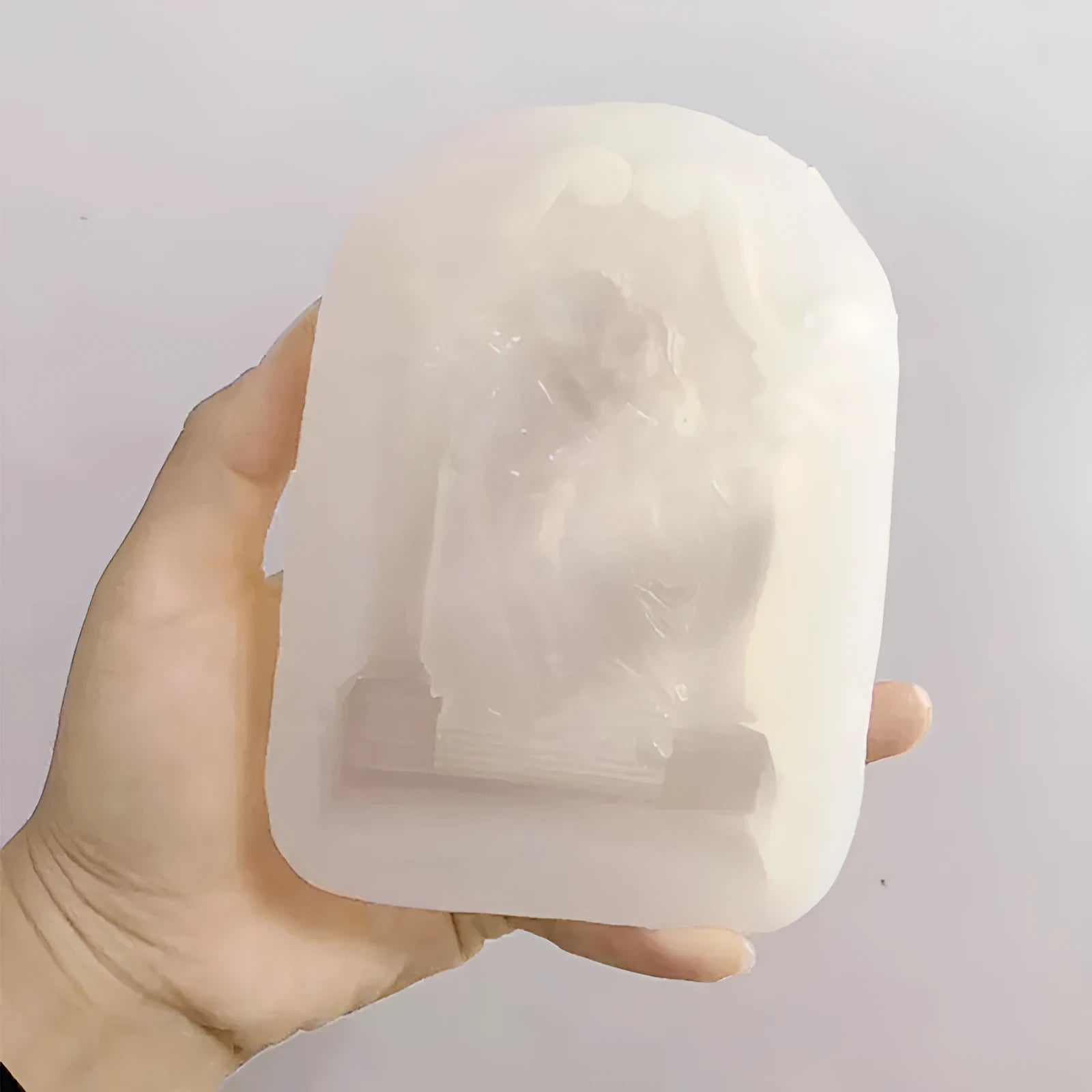 Flexible food-grade silicone mold for making hug angel couple figurines from wax, chocolate, or plaster.