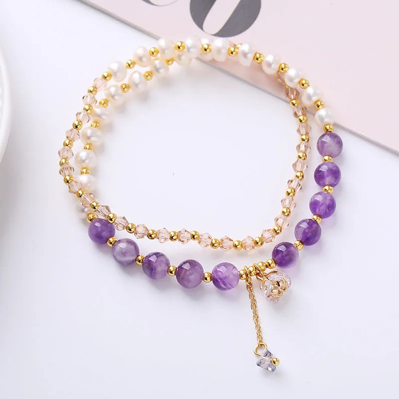 Close-up of a freshwater pearl and crystal double ring bracelet with a sliding bead closure.