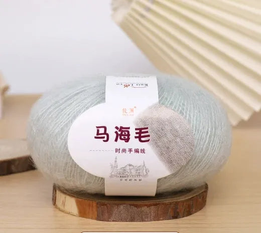 Ball of mohair yarn for DIY scarf knitting in one of 34 colours, including white, pink, blue, and green.