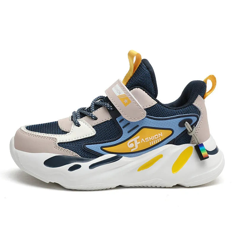 Boy's blue sports running shoe with velcro strap and mesh upper on a hard ground surface.