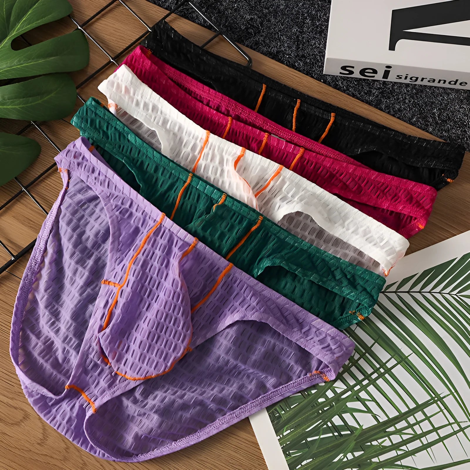 Men's low waist ice silk lace briefs in solid colours including rose red and light purple on a size chart.