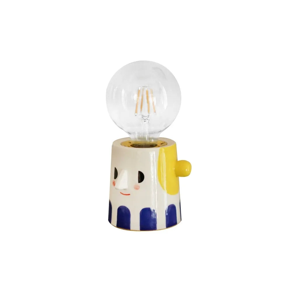 Handmade white ceramic table lamp with a spherical ball-shaped shade on a wooden surface.